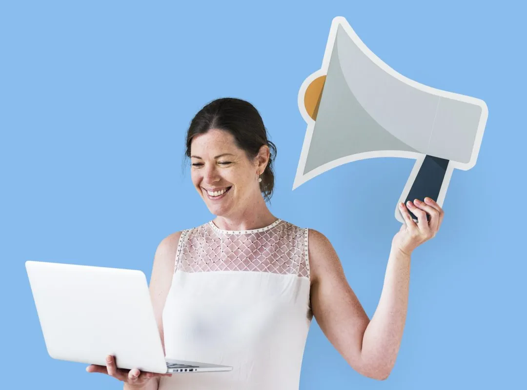 Woman holding a megaphone icon and using a laptop